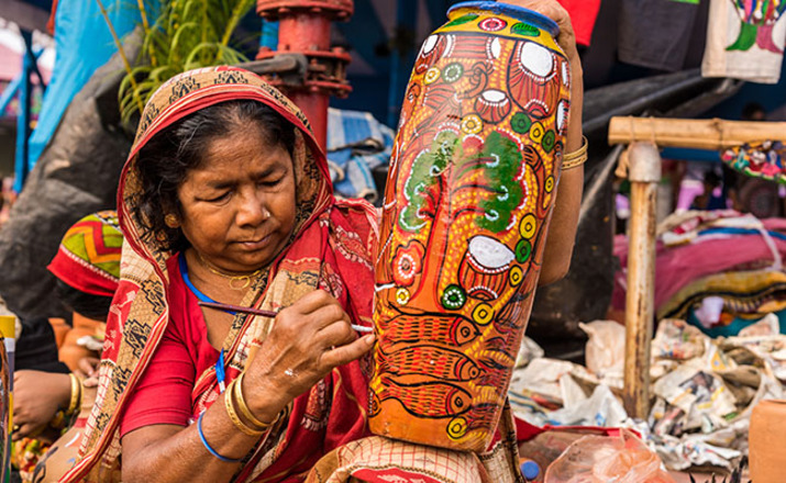 Artisan painting a colorful handmade craft